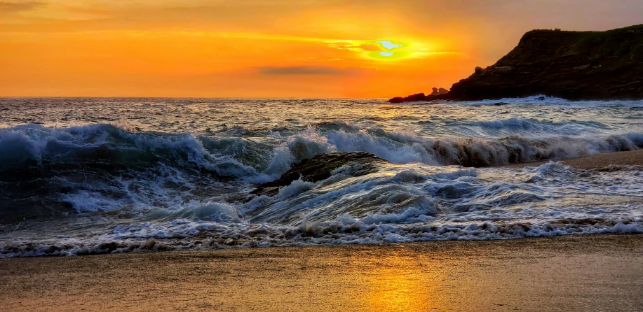 the sun rises over the water at the beach