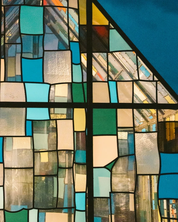 a stained glass window depicting multicolored squares of blue