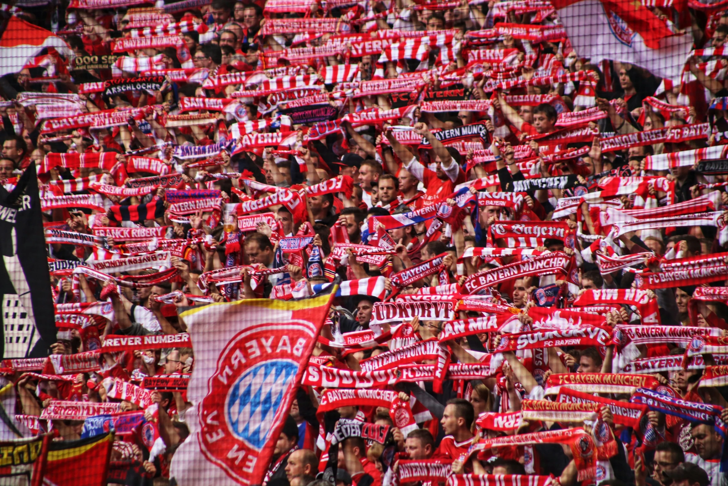 many soccer fans are seen holding red and white flags