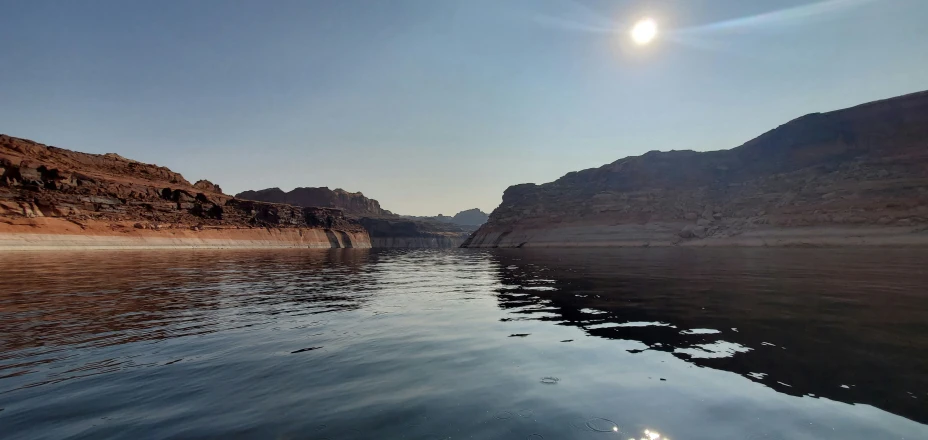 a body of water with a cliff in the background