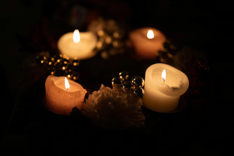 candles on a table with flowers in the dark