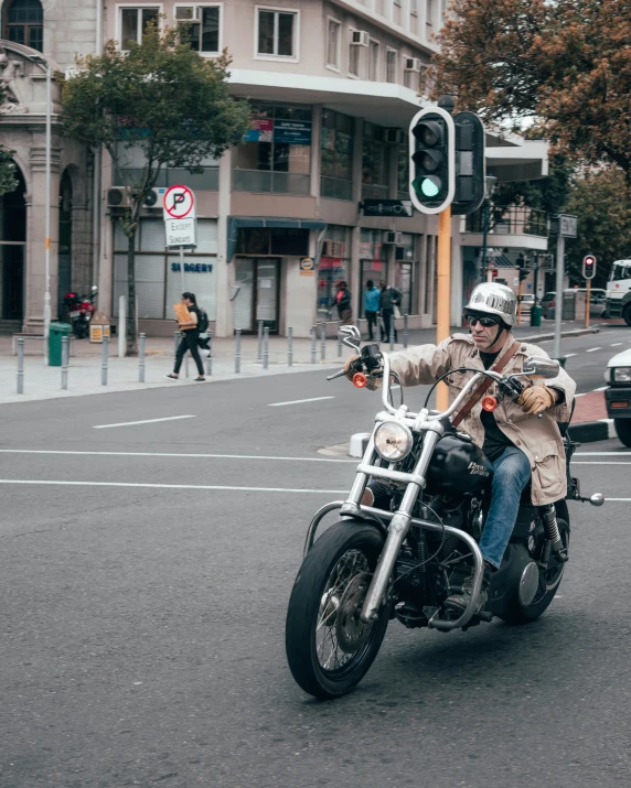 man on a motorcycle riding down the street