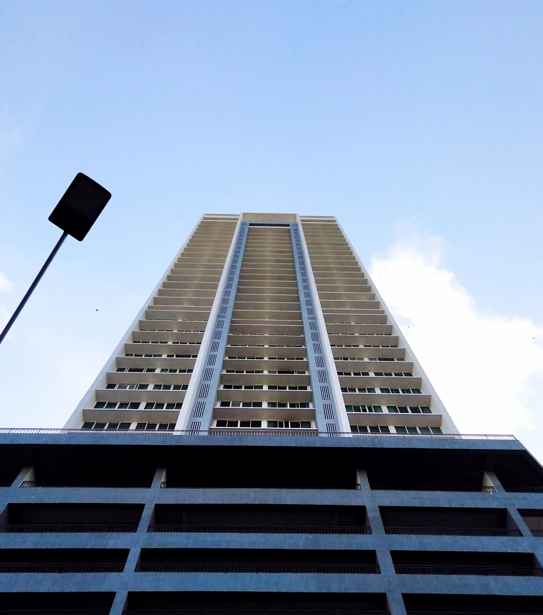 a tall building with a traffic light hanging from the side of it