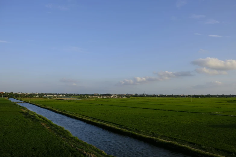 a wide grassy field and river in the foreground