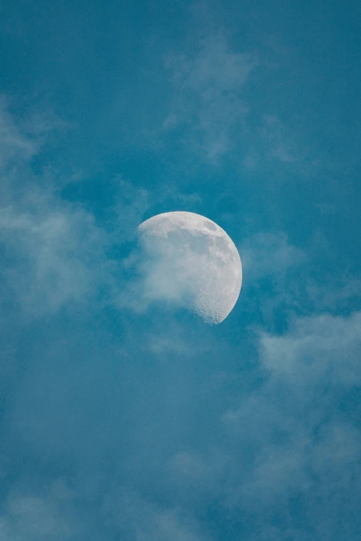 the moon with clouds in a blue sky