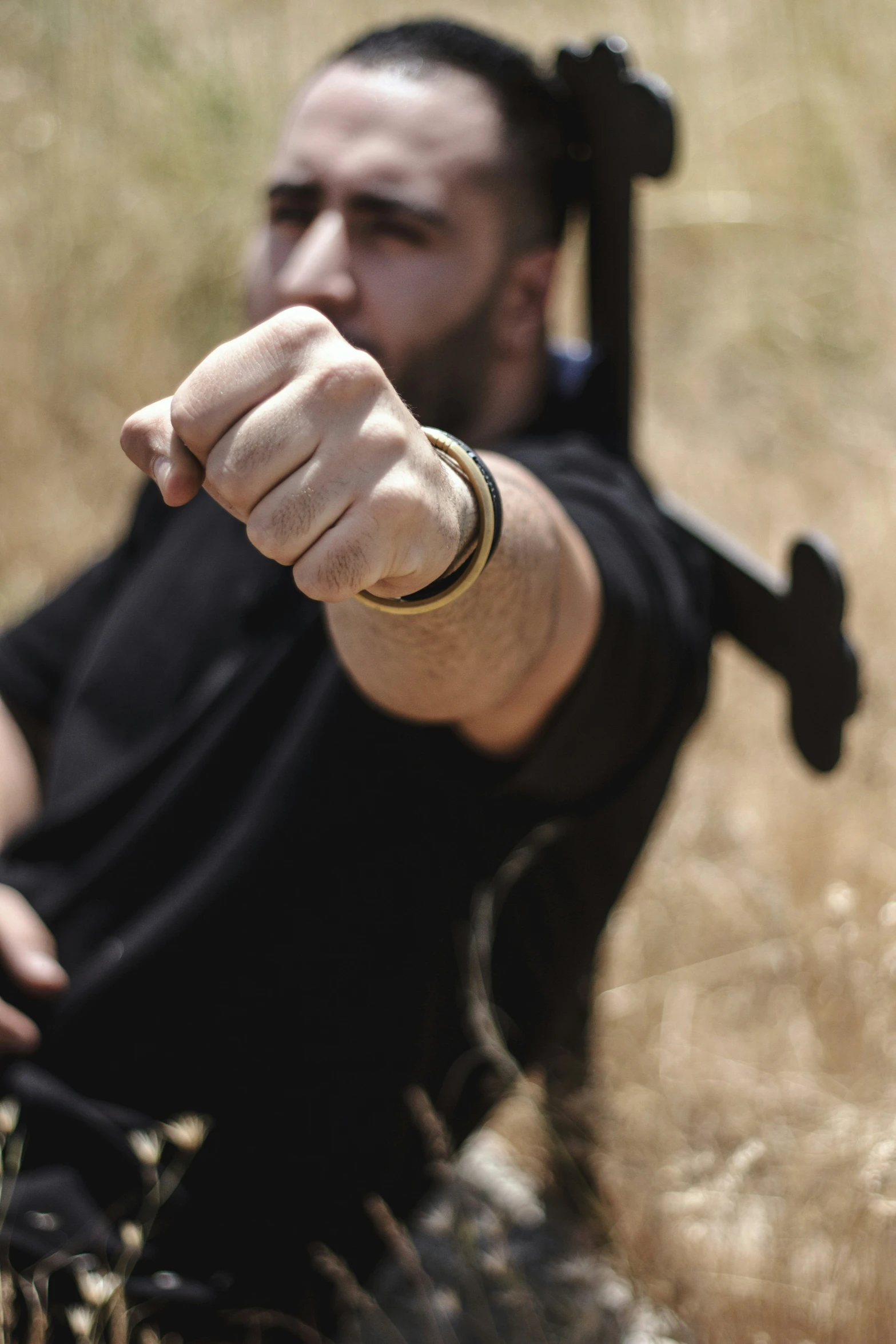 a person pointing with a black and gold ring