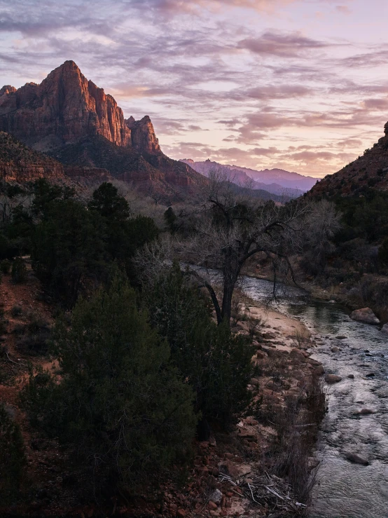 the view from a hiking trail at sunrise with mountains in the background