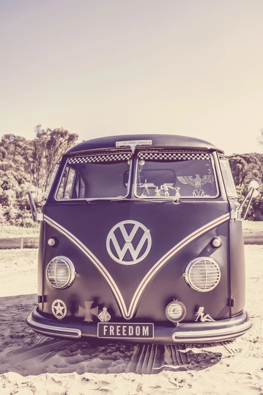 a black and white vw bus parked in the sand