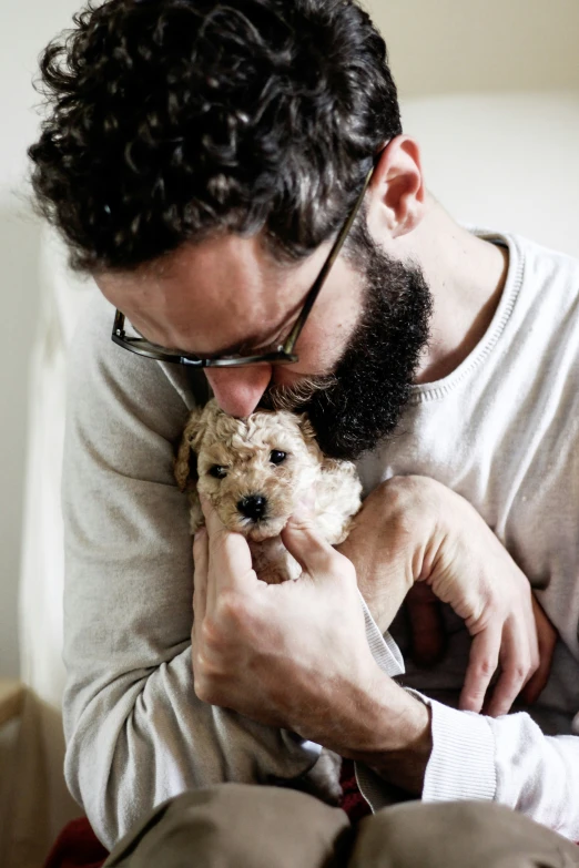 a man holds his dog and smiles at the camera