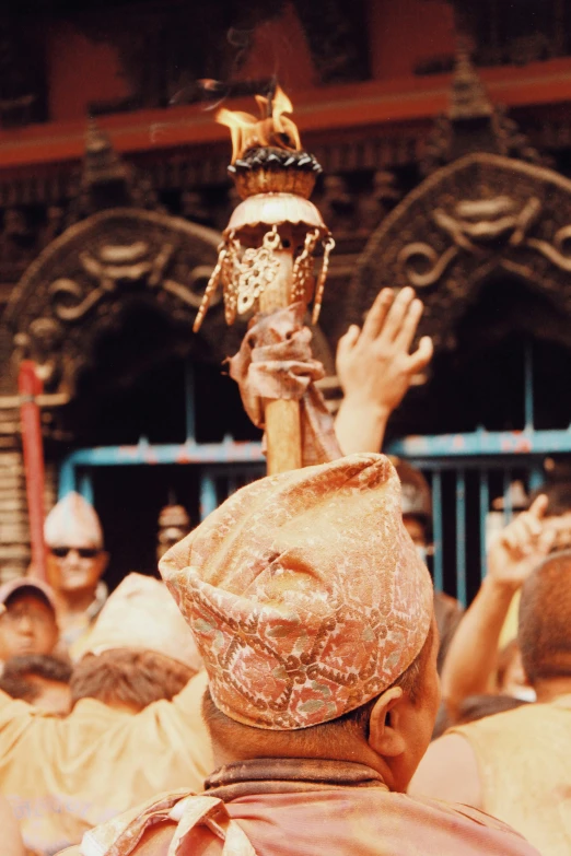 a man with a crown is raising his hands at a concert