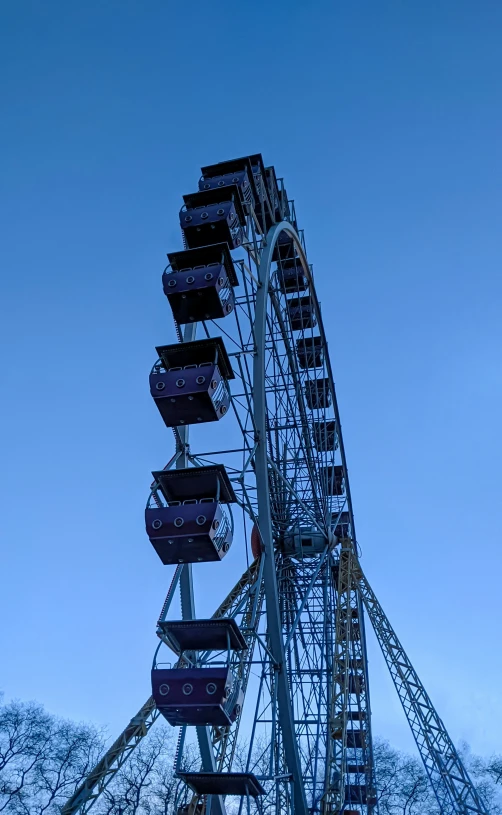 a ferris wheel against a dark sky with trees