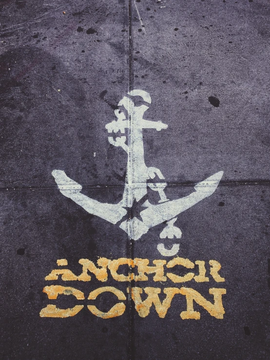 a painted anchor and some other words on a sidewalk