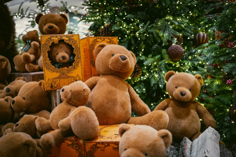 there are several brown teddy bears with an orange box on top