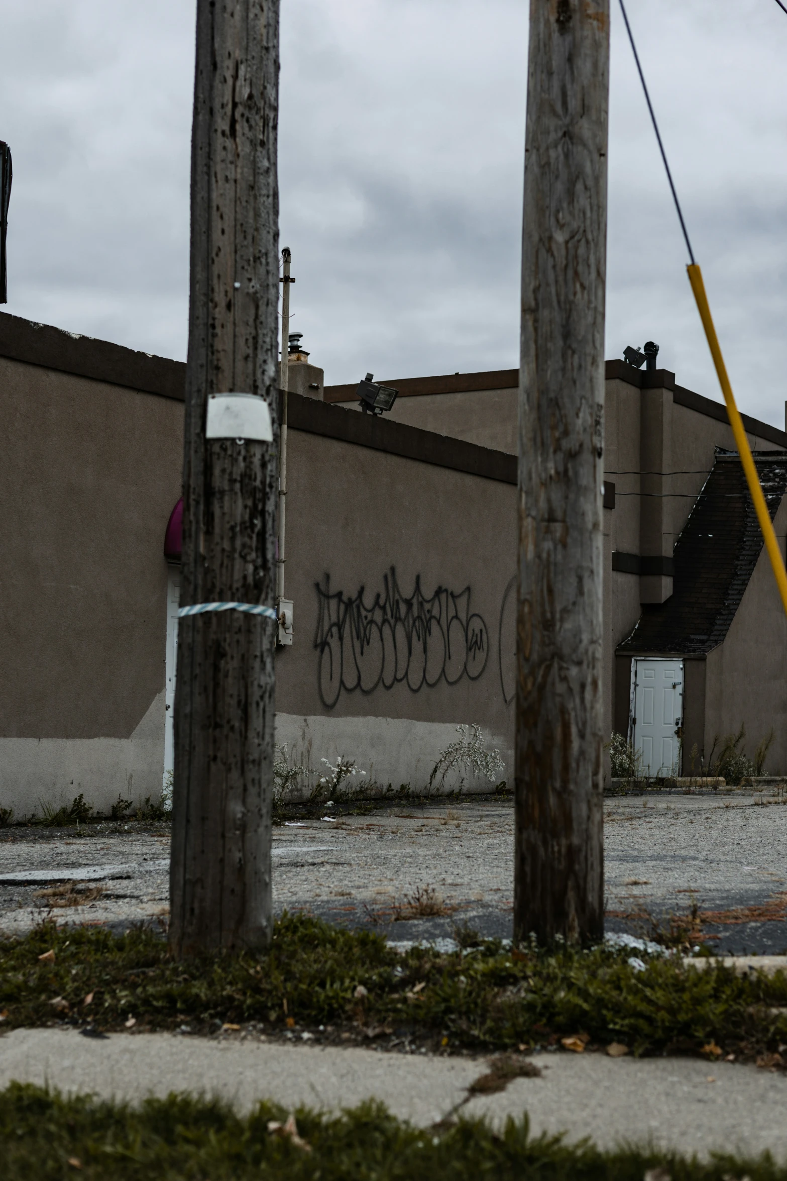 a wooden pole in front of a building that has graffiti on it