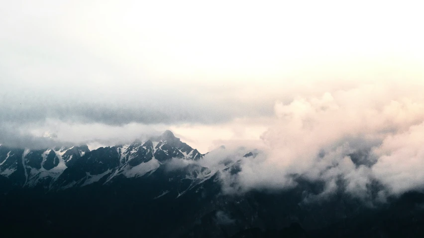 the top of a mountain covered in clouds