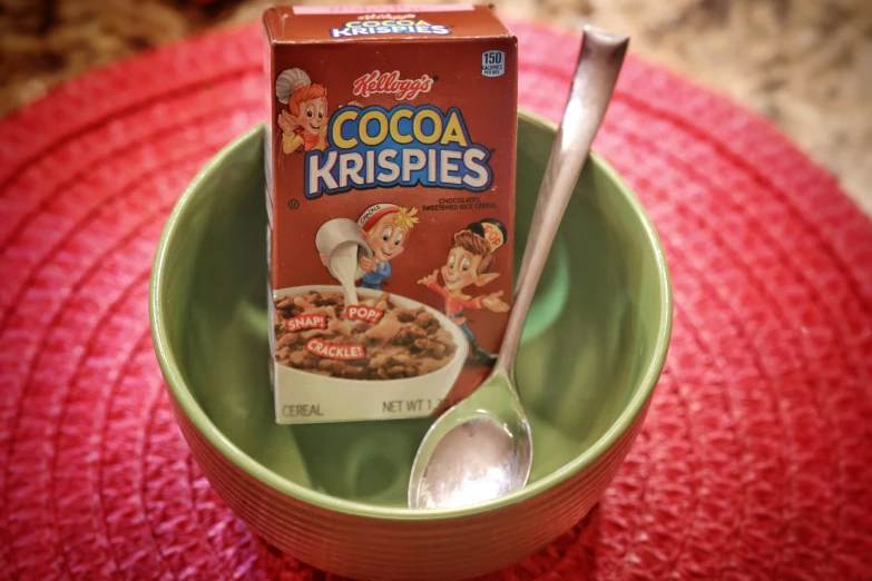 a bowl and spoon sitting next to a box of cereal