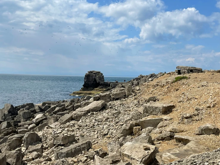 large rocks on the ground in front of an ocean