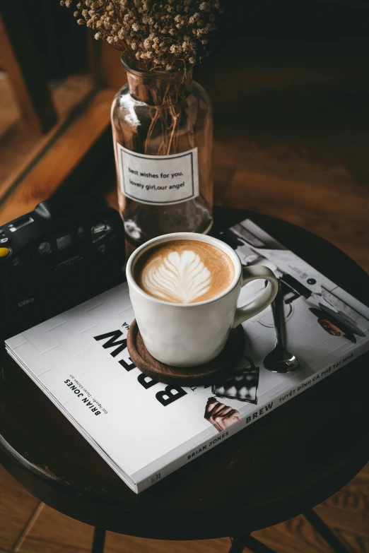 a book with a picture on top of it with a cappuccino