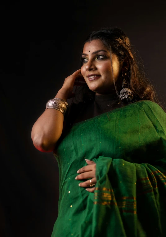 a smiling woman in a green and yellow saree