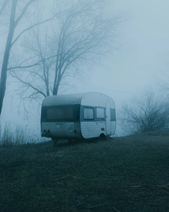 an abandoned camper sitting in the woods
