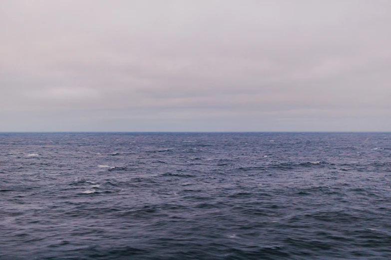 a small sail boat sailing across the ocean