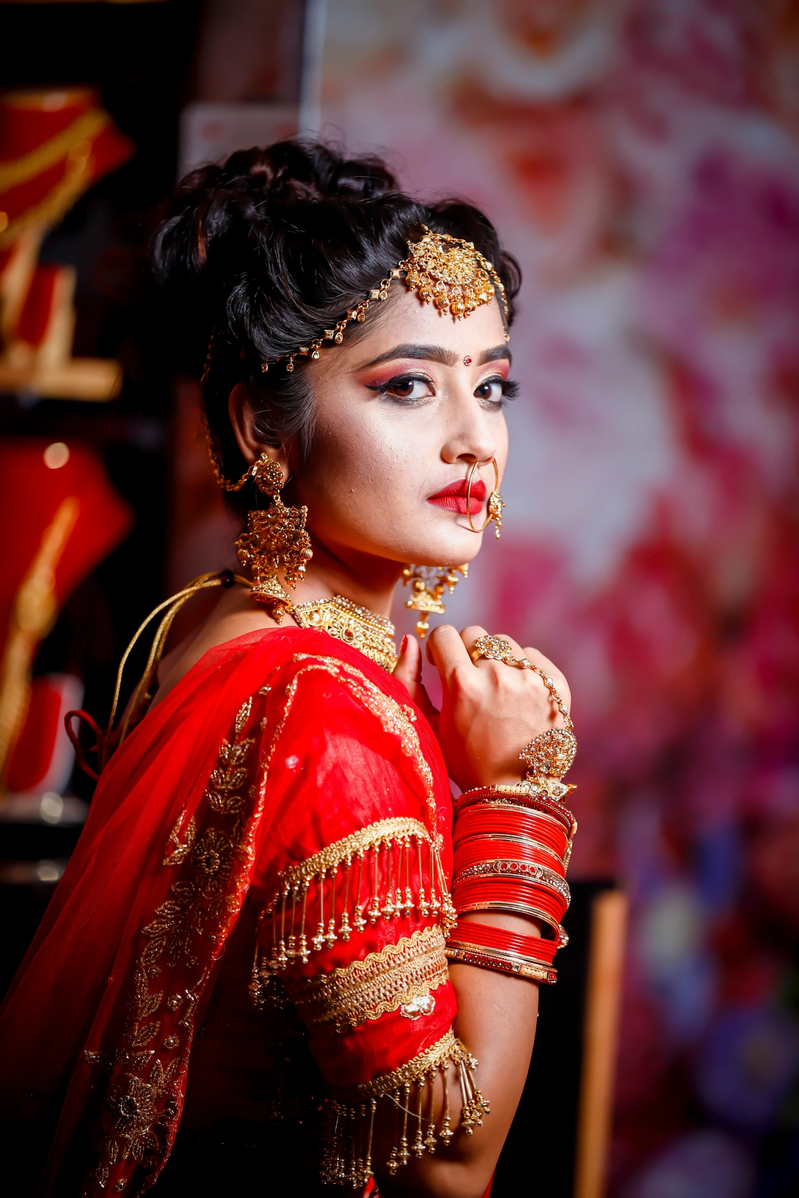 a woman in red indian wedding dress with makeup on