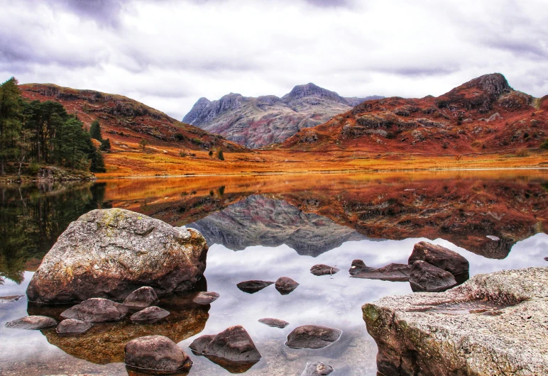 some rocks and water near some mountains