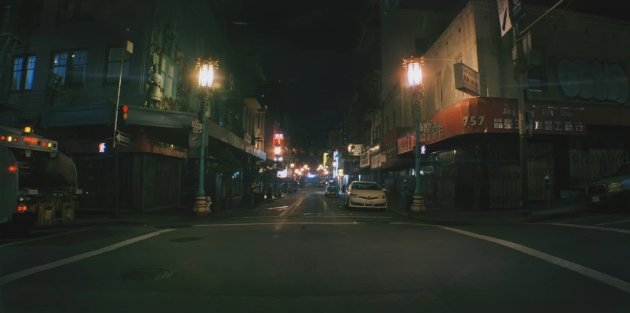 the street is dimly lit at night with traffic