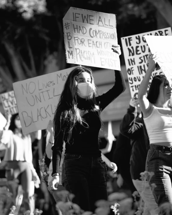 a group of women hold up signs with the words black lives matter