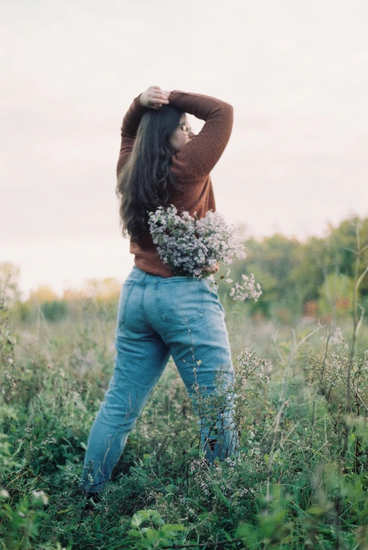 a woman is bending over her back in the grass