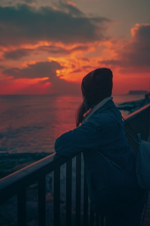 a person is standing on a rail in front of the sunset