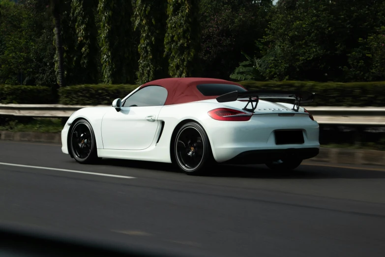 a white sports car driving down the road