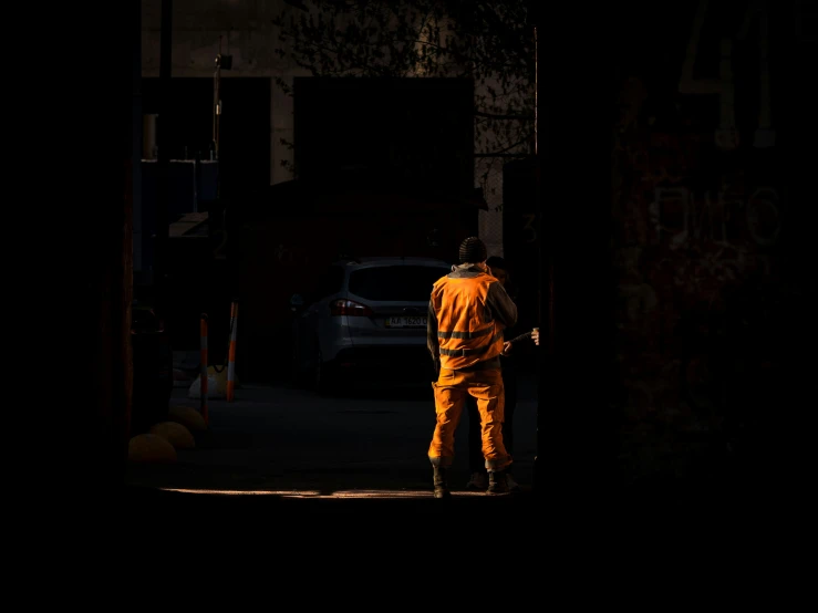 a man in an orange suit looking through a doorway