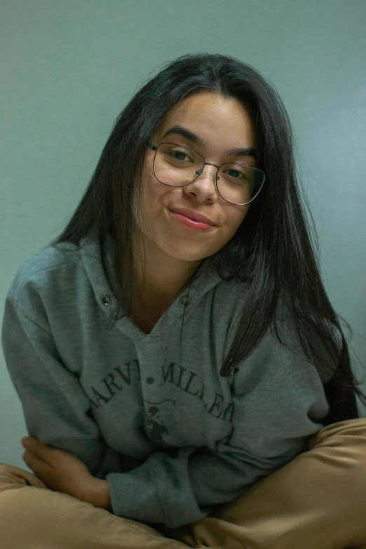 a woman with glasses and a hoodie posing for the camera