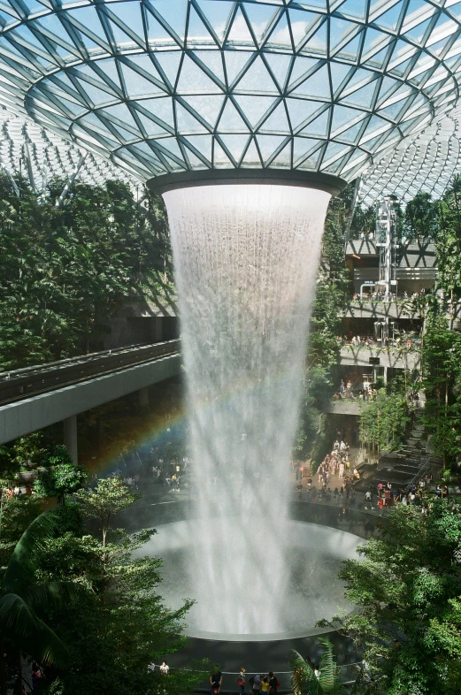 waterfall inside of a huge building with lots of greenery
