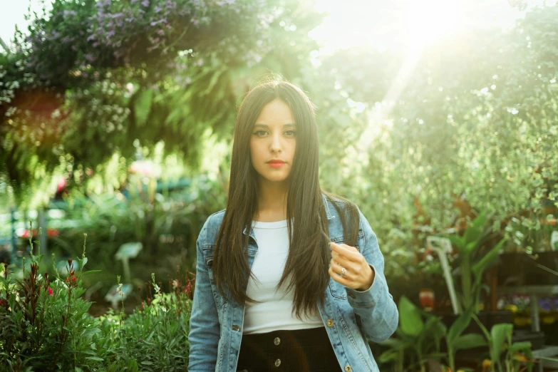 young woman looking down in the grass in an outdoor garden