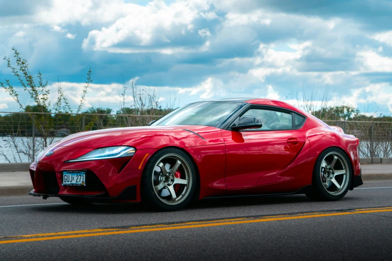 a red toyota sports car driving along a street