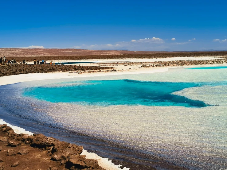 a blue river that has white sand near it