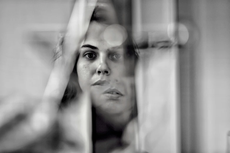 a woman looking at her reflection in the mirror