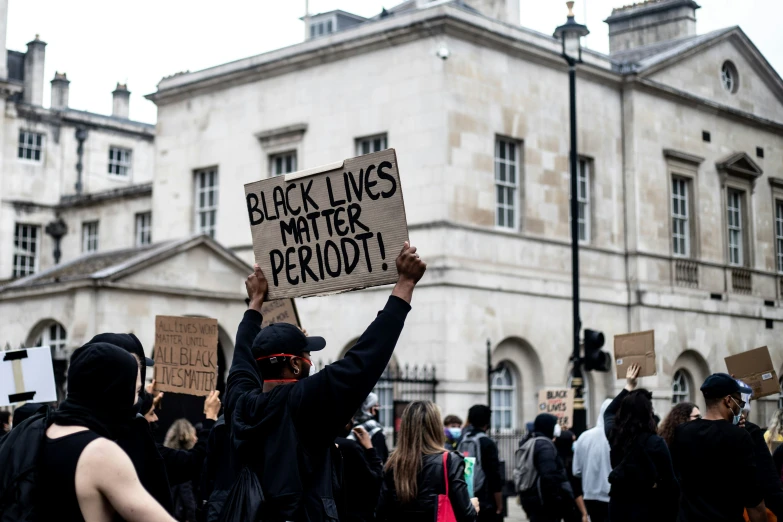 a crowd is protesting in front of an old building