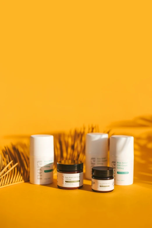 three jars sitting next to each other on top of a yellow background