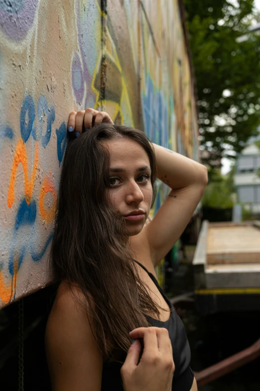 a woman standing near a colorful wall looking at the camera