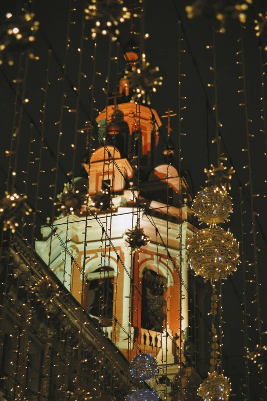 christmas lights are hanging from the light poles on the steeple