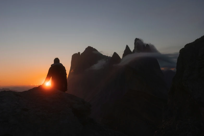 a person is sitting on top of a mountain