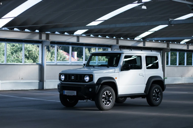 a white jeep is in the middle of the empty parking lot