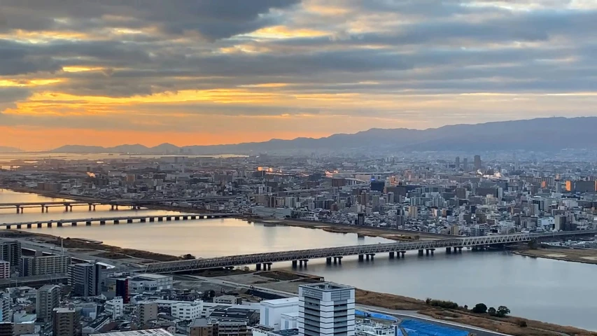 cityscape with large bridge in the background during sunset