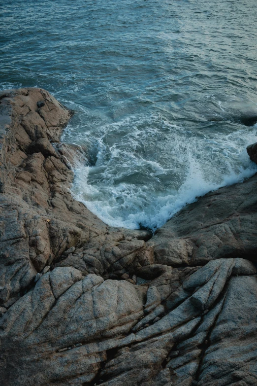 the waves are crashing on rocks in the ocean