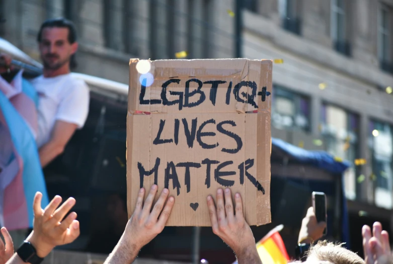 protestors holding placard with message saying legitq lives matter