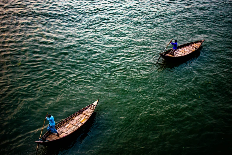 two people are riding in small boats on the water