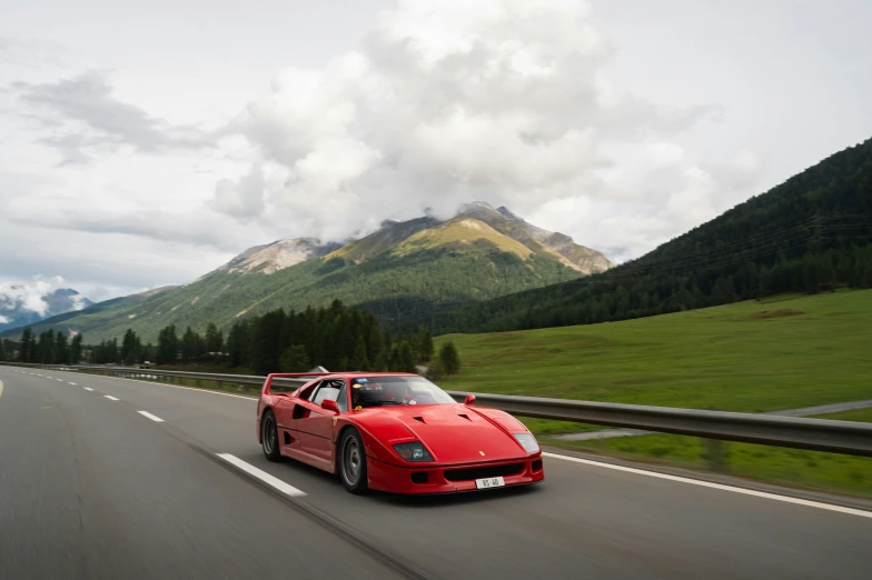 a red sports car driving down the road